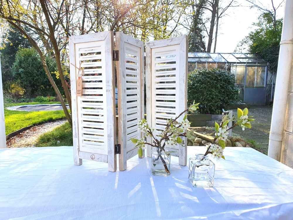 Raamshutter wit 52 cm Ibiza White op tafel in de tuin met bloesemtakken
